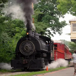 a steam train on a track with smoke coming out of it