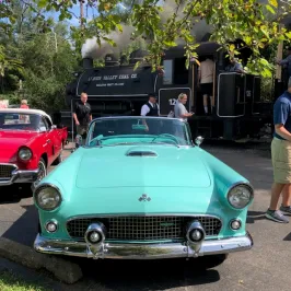 a group of people standing on top of a car