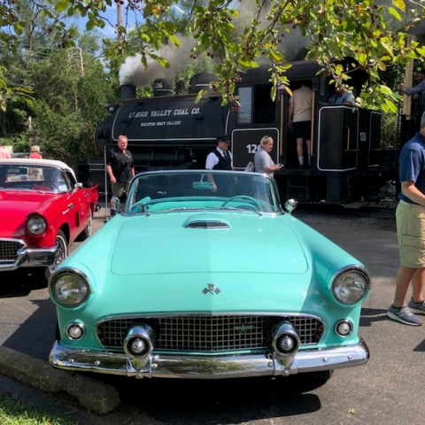 a group of people standing on top of a car