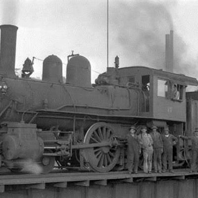 an old photo of a train on a steel track