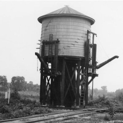 an old photo of a structure next to a train track