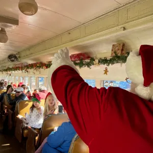 a group of people inside a train with Santa