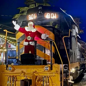 a train on a steel track with Santa at the front